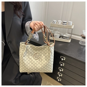 Detail of monogram M patterned tote bag with metal logo and leather chain strap