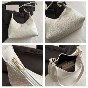 Detailed view of white woven PU leather handbag with gold zipper and spacious interior
