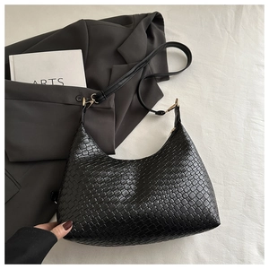 Detailed view of black woven PU leather underarm bag with minimalist fashion design