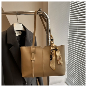 Khaki faux leather tote bag detail featuring V-cut seam and decorative printed silk scarf