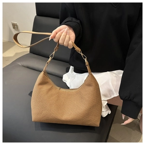 Détail d'un sac hobo tissé avec bandoulière en cuir réglable et boucle métallique