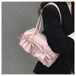 Dettaglio ravvicinato del fiocco rosa su una borsa a tracolla in pelle alla moda