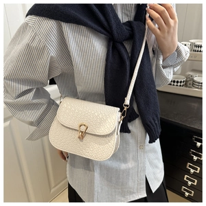 Detail of white crocodile pattern shoulder bag with a gold horseshoe metal buckle