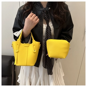 Detail of yellow pebbled leather bucket bag with matching small zippered cosmetic pouch