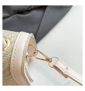 Detailed close-up of golden metal clasp and woven fabric on a vintage crossbody box bag