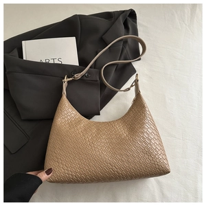 Detailed macro view of beige woven PU leather underarm bag with minimalist design and strap