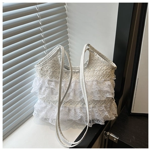 Detailed macro shot of white tiered lace ruffles and delicate texture on a tote bag