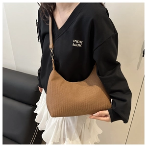 Vue détaillée de la texture tissée marron sur le sac porté épaule en cuir demi-lune