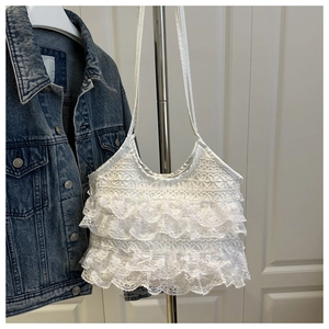 Detailed close-up of white lace camisole featuring multi-layer ruffles and floral texture