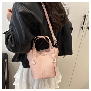 Detailed view of pink lychee texture bucket bag with metal rivet hardware and strap