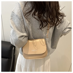 Détail du sac selle beige avec texte Fashion Trend porté par un mannequin en mode de vie