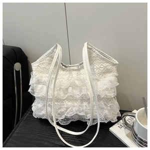 Close-up of white layered lace tote bag with delicate ruffles and thin shoulder straps