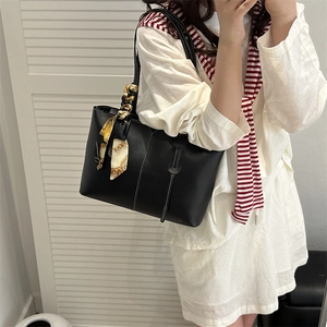 Large black tote bag with white contrast stitching and a printed silk scarf on handle