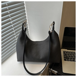 Close-up of black hobo bag featuring woven herringbone texture and gold hardware detail