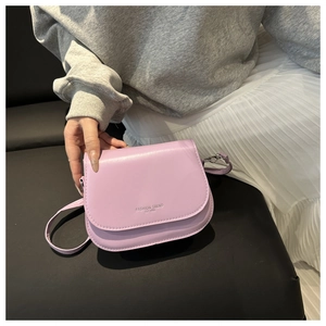 Détail du sac selle lilas en similicuir avec texte Fashion Trend Est 1996 embossé