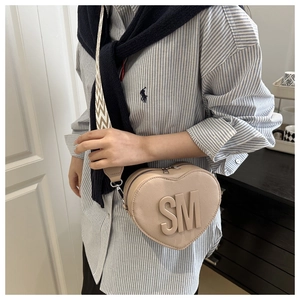 Detail of heart-shaped crossbody bag featuring SM logo and wave pattern wide strap