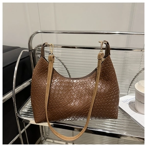 Detail view of the woven texture and sleek strap of the brown PU underarm tote bag.