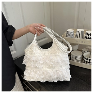 Close-up of white ruffled lace tote bag showing delicate layered fabric and handles