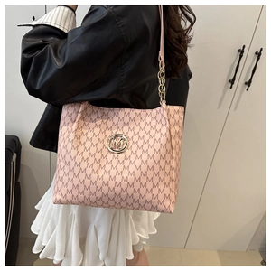 Detailed view of pink tote bag with M-pattern print and gold chain shoulder strap