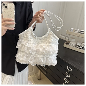 Close-up of white tiered lace handbag with elegant layered ruffles and slim handles