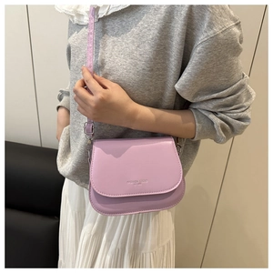Model wearing a lavender purple PU leather saddle bag with adjustable strap and flap closure