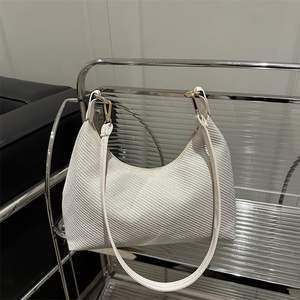 Sac fourre-tout tissé blanc minimaliste avec détails dorés sur étagère moderne