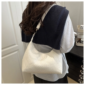 White woven PU leather underarm bag for women shown on a model in a casual setting