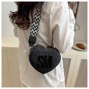 Detail of heart-shaped black crossbody bag with SM logo and zigzag wide strap