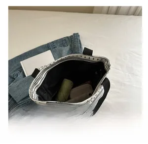 Détail de l'intérieur spacieux du sac fourre-tout rayé avec parapluie et téléphone