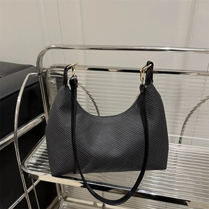 Minimalist black hobo shoulder bag with textured fabric and gold metal hardware
