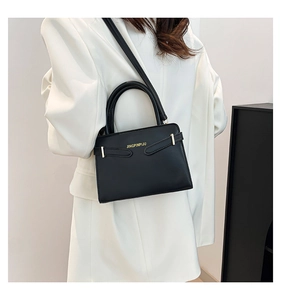 Détail du sac bandoulière en cuir noir mat avec logo doré et bandoulière fine