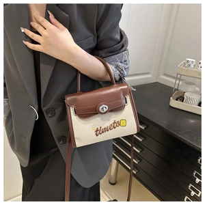 Detail of color-block Kelly bag with brown leather, beige canvas, and timeto logo