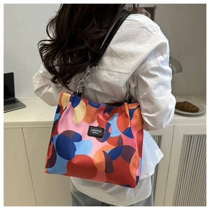 Modern waterproof nylon tote bag with colorful pattern shown in a home office setting