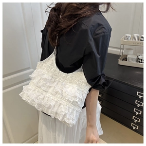 Detailed view of layered white lace tote bag with delicate ruffles and floral crochet work