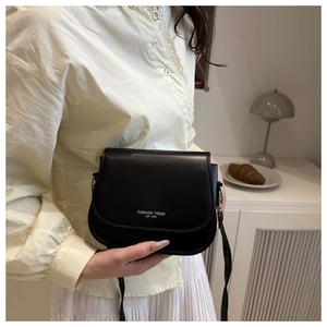 Detail of matte black saddle bag featuring white Fashion Trend EST 1996 logo print