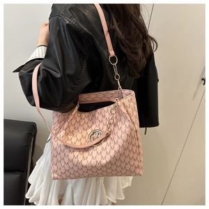 Detail of light pink tote bag with M letter print and gold chain strap on model