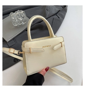 Détail d'un sac à main en cuir PU blanc crème avec logo doré et bandoulière réglable