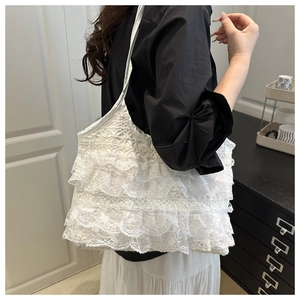Close-up of white layered lace pleated tote bag on model for elegant French romantic style