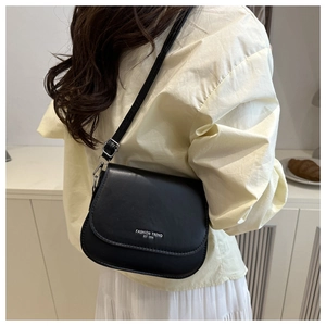 Detail of black saddle bag with adjustable strap and Fashion Trend logo engraving