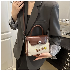 Detail of canvas and leather contrast crossbody bag worn with a gray suit
