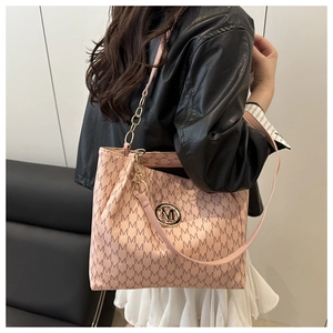 Detail of pink tote bag featuring all-over M monogram print and gold metal logo