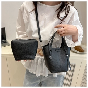 Detail of black lychee grain leather bucket bag set with matching zipper clutch
