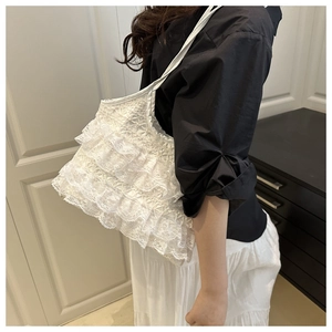 Detailed side view of a white lace tiered tote bag showing intricate ruffle textures