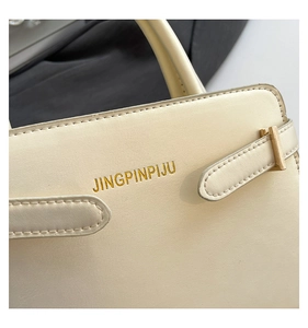 Détail du sac à main blanc cassé avec logo JINGPINPIJU doré et boucle en métal chic