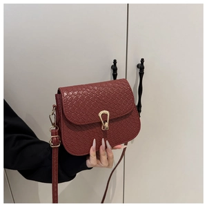 Close-up of wine red woven texture small square bag with golden horseshoe lock buckle