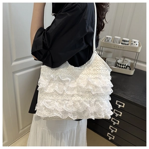 Detail view of white lace tote bag with tiered ruffles and romantic hollow flower pattern
