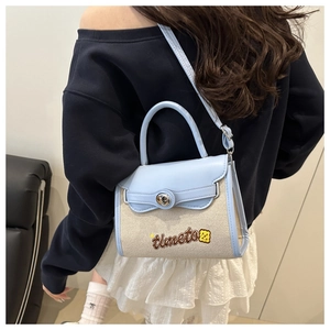 Detail of canvas patchwork bag with blue leather trim and timeto embroidery