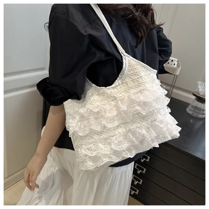 Detail of white lace mesh shoulder bag with ruffles on a model in modern interior