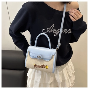 Detail of light blue and beige contrast crossbody bag worn by model for casual style
