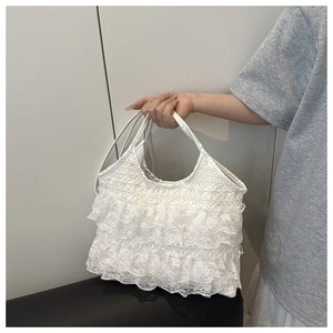 Detail of white lace pleated handbag featuring delicate layers and thin shoulder straps